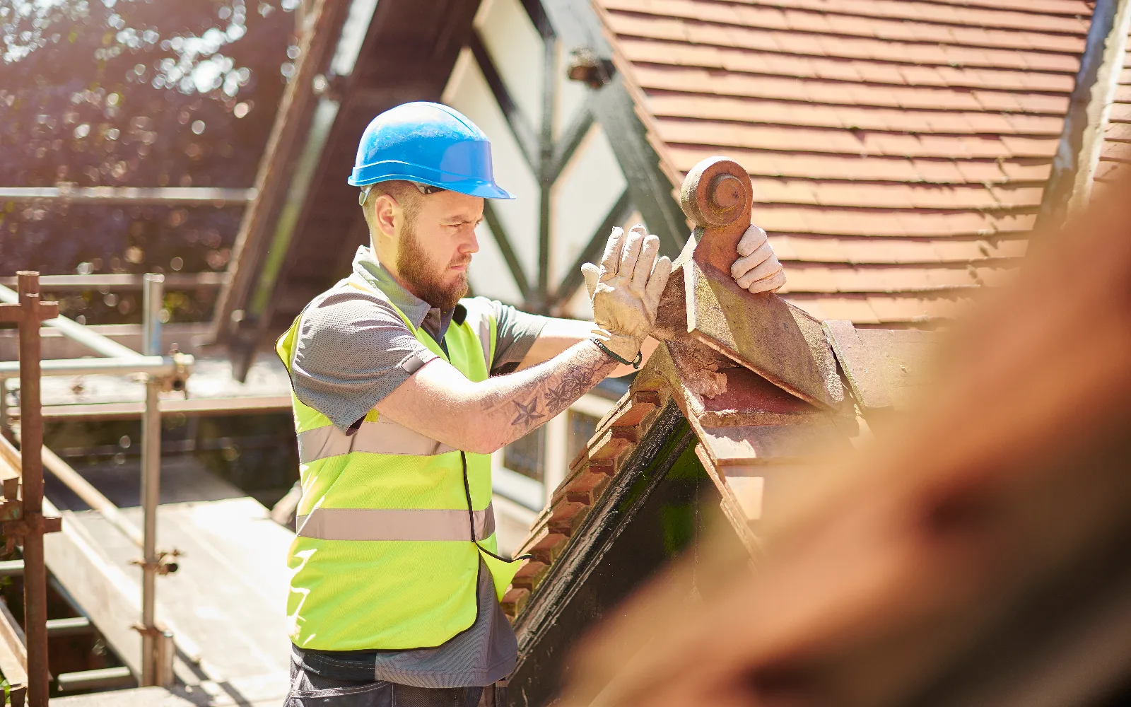 A roofer laying clay roof tiles
