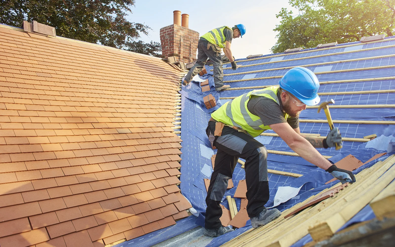 Roofers laying new tiles on a re-roof